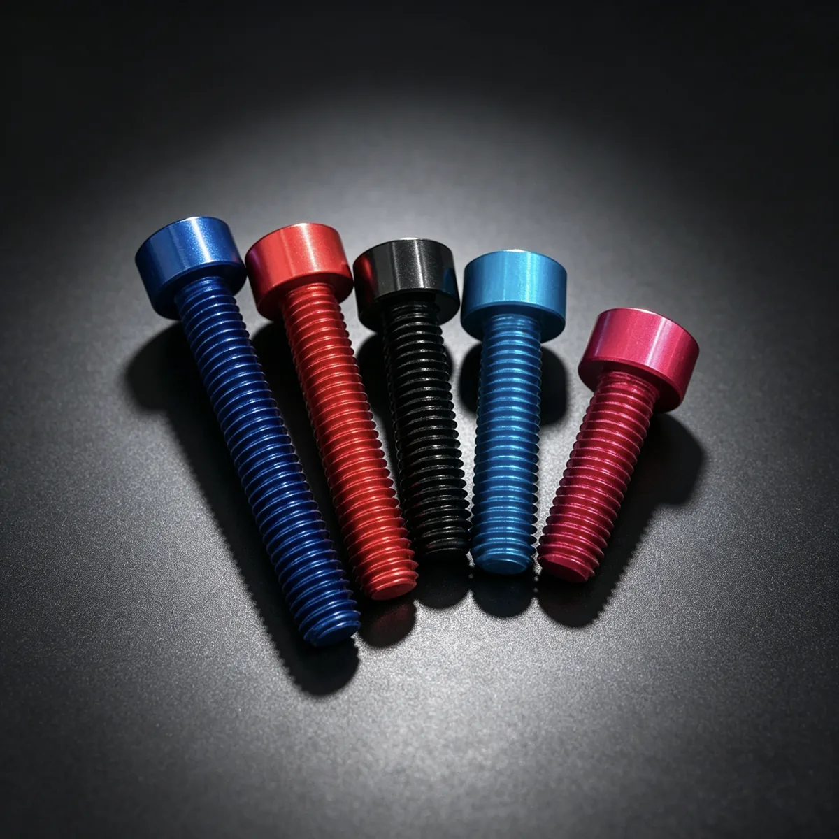 Anodized aluminum fasteners in multiple colors on a dark background