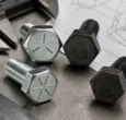Hex bolt heads with SAE radial lines and metric 8.8 and 10.9 markings on an inspection bench