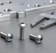 Stainless steel button head screws with a caliper on an inspection bench