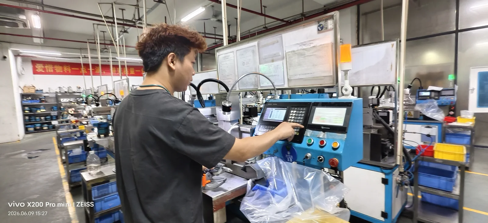 Operator reviewing an in-process fastener sample at a production machine